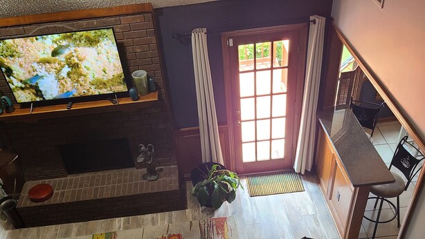 A living room with a television, a fireplace, a colorful rug, a sofa, and a dining area with a table and chairs. - Vacation home just 21 minutes from Historic Beale Street and Graceland (Memphis)
