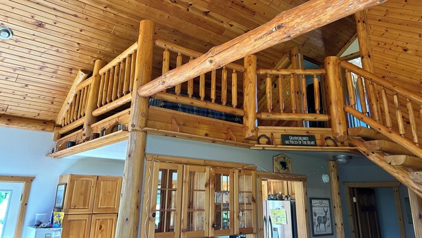 A wooden cabin interior with a balcony, wooden cabinets, and a ceiling fan. - National Forest, Fishing, Trail riding, Hunting, Bars/Eatery and Pet-Friendly (Gilman)