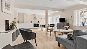Un espacio moderno de estar con cocina, comedor y asientos.