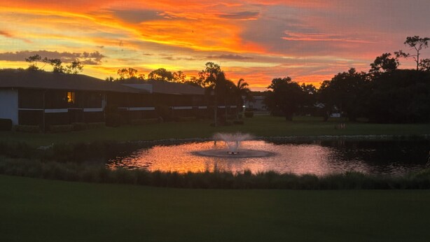 A sunset over a residential area with a pond and houses. - Resort - Style Condo in Naples, Florida (Naples)