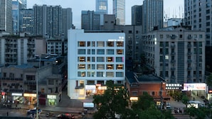 A modern hotel with a prominent 'BOOK IN HOTEL' sign, surrounded by high-rise buildings and a busy street. - Book'in Hotel (Changsha)