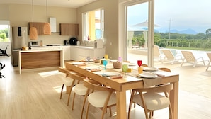 A modern kitchen with a dining area, large windows, and a view of the outdoors. - Mágica CASA FINCA de lujo piscina wi-fi (San Sebastian de Mariquita)