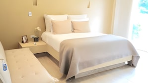 A modern bedroom with a bed, bedside tables, and a bench. - Mágica CASA FINCA de lujo piscina wi-fi (San Sebastian de Mariquita)