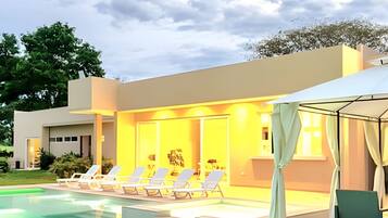 Relax by the pool surrounded by lush greenery and trees.