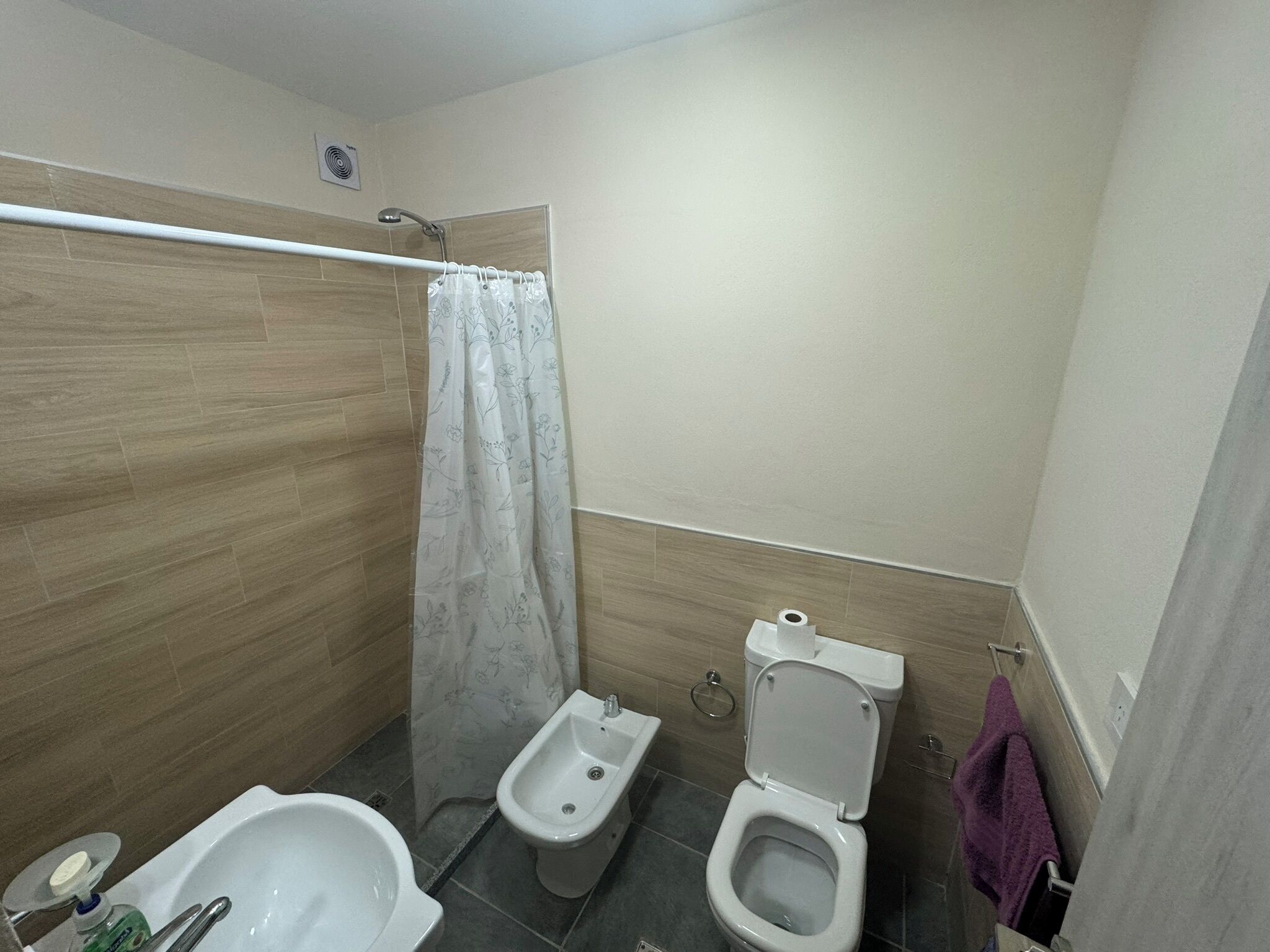 A bathroom with a shower, bidet, toilet, and a bathtub.