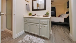 A bathroom with a vanity, mirror, towel rack, and a sign that says "be KIND". - Cozy Family Retreat: Coffee Bar, Game Room and Pet Friendly (Lodi)