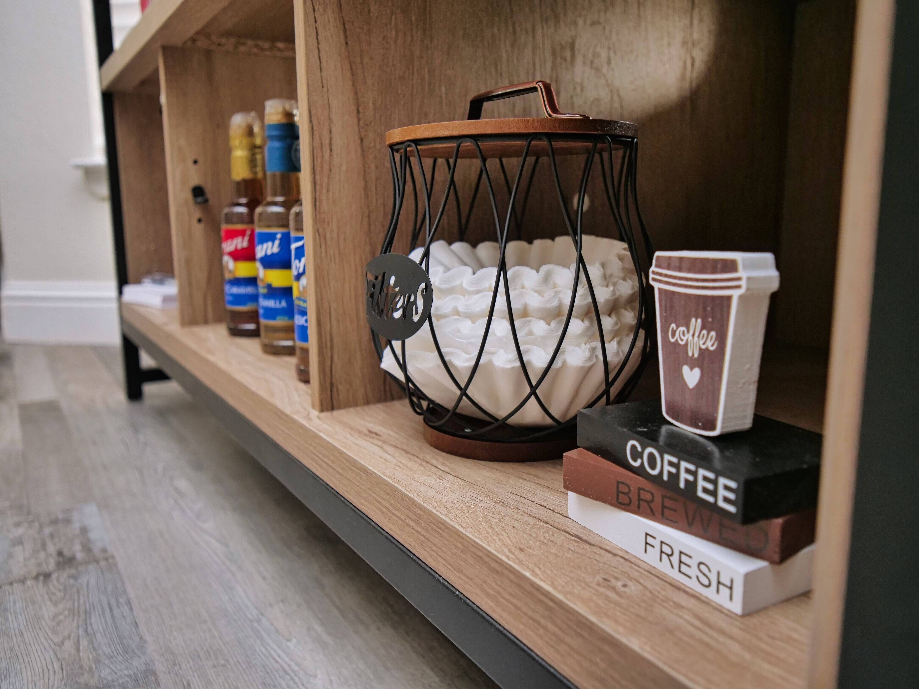Una repisa con una cafetera, una taza de café y una caja que dice "COFFEE BREWED FRESH".