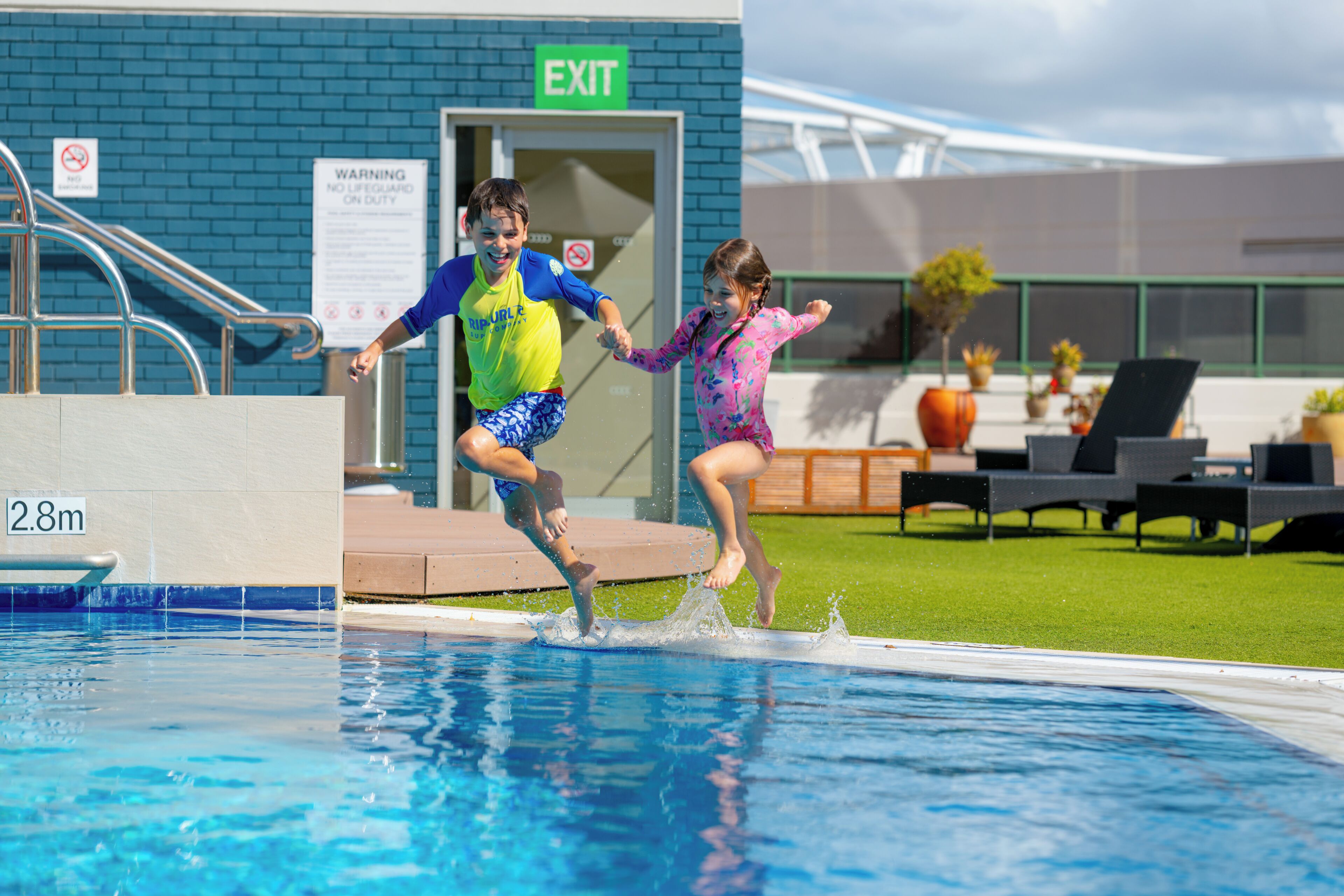 Une piscine avec un panneau indiquant une profondeur de 2,8 mètres.