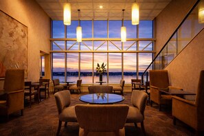 A conference room with a large table, chairs, and a view of the cityscape at sunset. - Residence on Langley Park (East Perth)