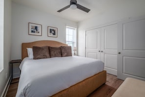 A bedroom with a bed, a ceiling fan, a window, and a wardrobe. - Beautiful Main Street Living in Trussville  (Trussville)
