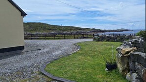 A coastal property with a gravel driveway leading to a stone wall and a grassy area. - Apartment 471 - Clifden - sleeps 4 guests  in 2 bedrooms (Clifden)