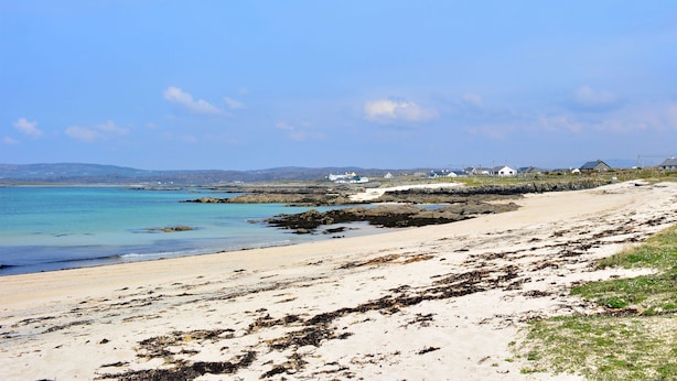 A coastal beach with clear blue waters, sandy shore, and houses in the background. - Apartment 471 - Clifden - sleeps 4 guests  in 2 bedrooms (Clifden)