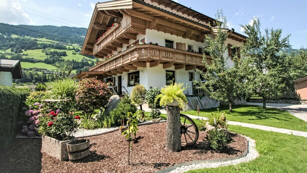 A traditional chalet with a wooden balcony, surrounded by a well-maintained garden with various plants and flowers. - Paradiso by Interhome (Ramsau im Zillertal)