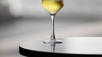 Een wijnglas met een witte vloeistof op een ronde tafel.