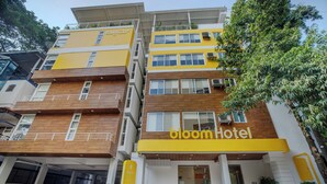 A multi-story hotel with a yellow facade, multiple balconies, and a sign reading "bloom hotel". - Bloom Hotel - HAL Old Airport Rd (Bengaluru)