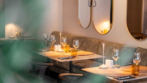 A restaurant with a cozy seating area, candle-lit tables, and a modern decor.