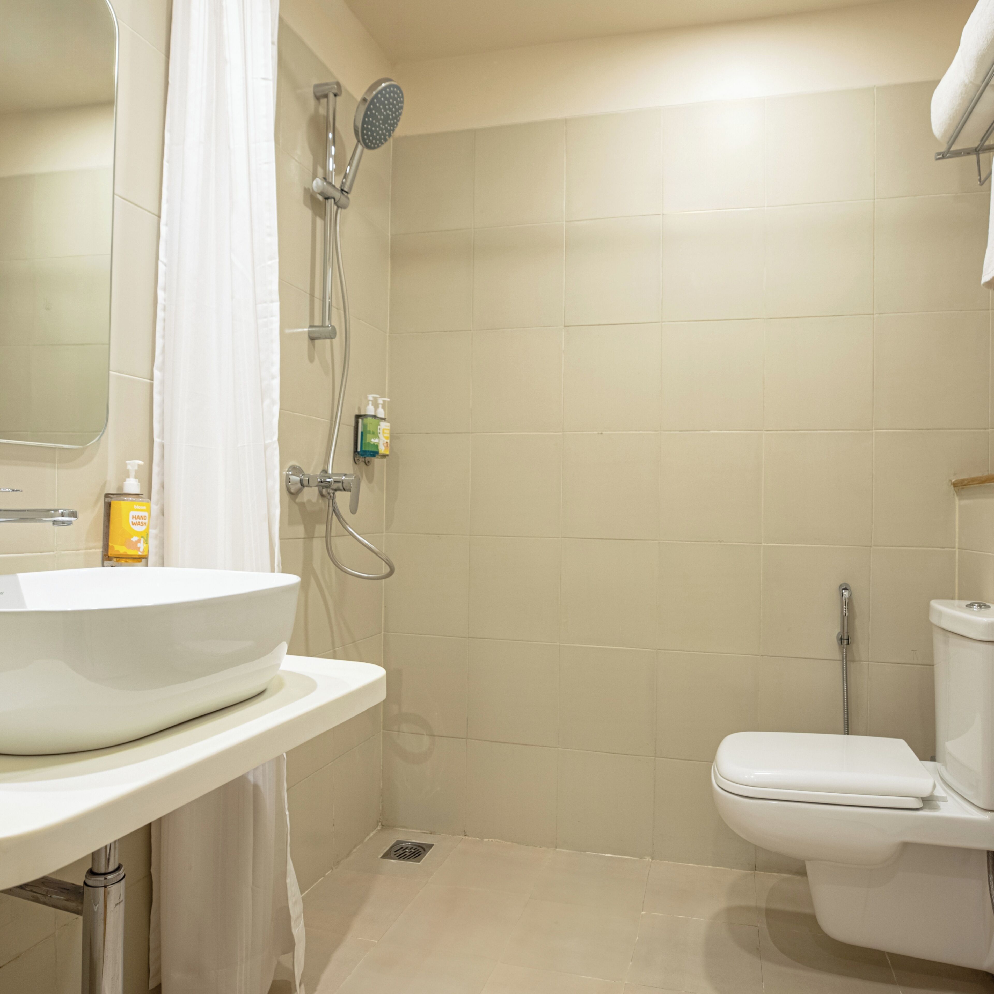 A bathroom with a white sink, toilet, and shower.