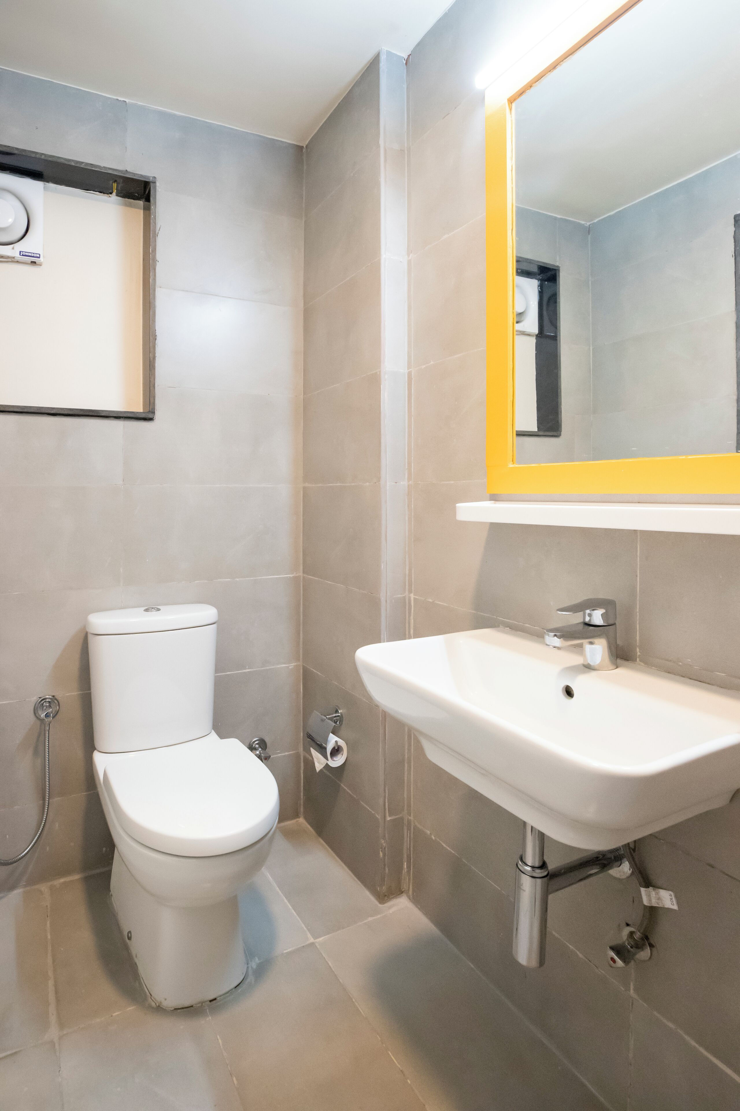 A modern bathroom with a toilet, sink, and mirror.