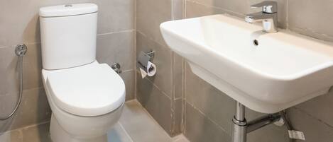 A modern bathroom with a toilet, sink, and mirror.