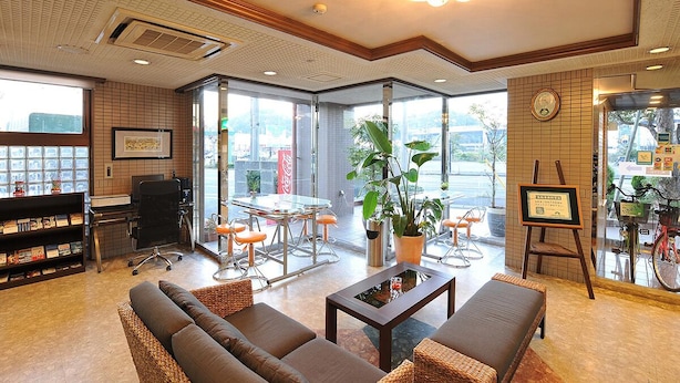 A spacious lobby with a seating area, a coffee station, and a view of the street. - HOTEL CROWNHILLS NARUTO (Naruto)