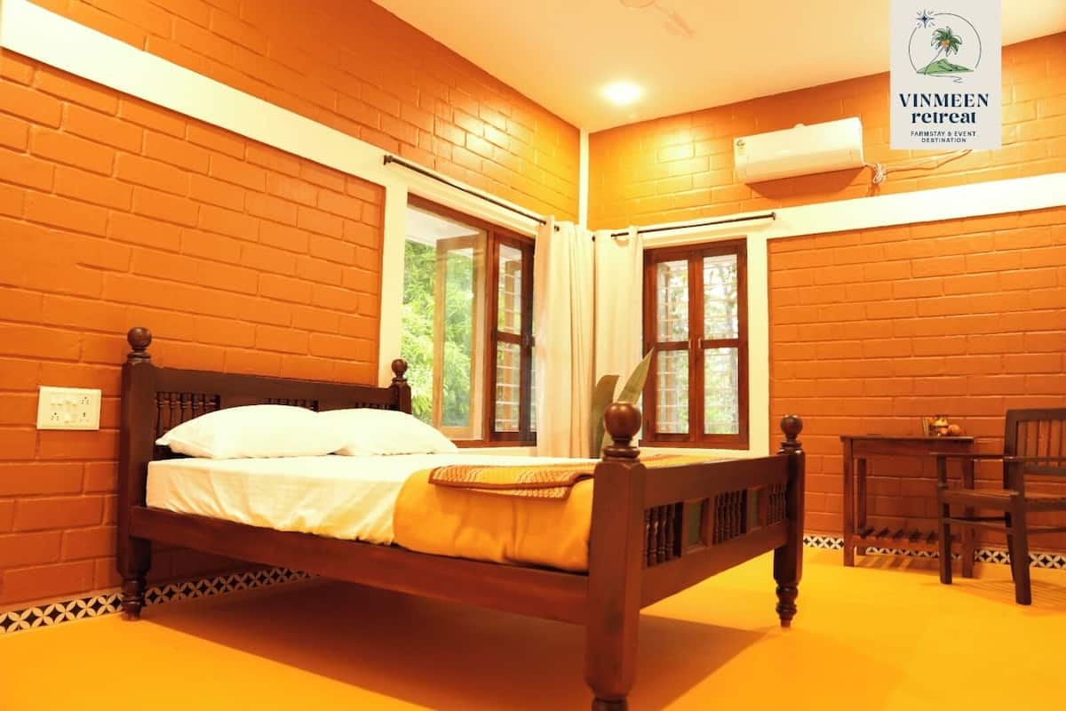 A room with a wooden bed, a small table, and a chair.