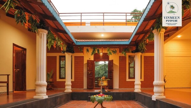 A spacious courtyard with a central fountain, surrounded by columns and a tiled floor. - TRK Farms Vinmeen Retreat (Katpadi)