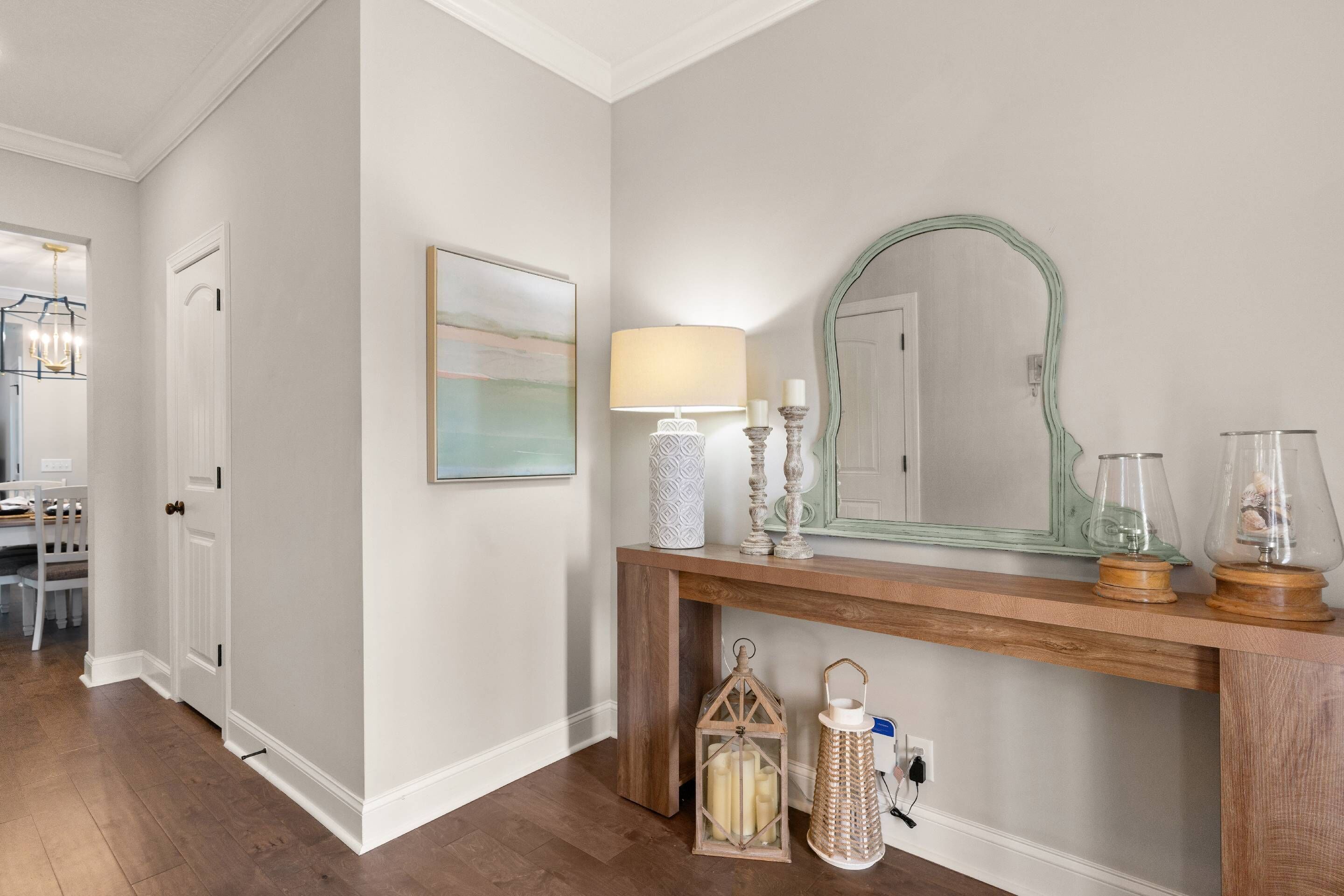 A hallway with a wooden console table, a mirror, and decorative items.