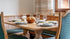 A dining table set with plates, glasses, and a basket of bread. - Cosy apartment for families (Alpbach)