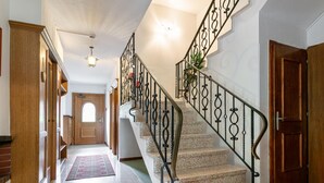 Un escalier orné de rampes en métal travaillées, menant à un palier.