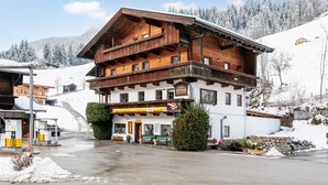 Un bâtiment traditionnel en bois, doté de plusieurs balcons, d’un magasin et d’une station-service, situé dans un paysage enneigé.