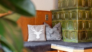 Un espace aménagé avec un banc et des coussins, un mur en bois et une pile de carreaux verts.