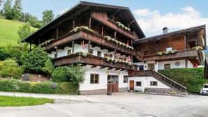 A traditional wooden chalet with multiple balconies, a stone foundation, and a sign indicating it is a workshop and restaurant. - Beautiful apartments by the ski lift in Alpbach (Alpbach)