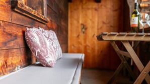 A wooden interior with a bench and a table with wine bottles and glasses. - Right by the ski lift - 2 apartments in Alpbach (Alpbach)