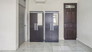 A hallway with two dark-colored doors, a closed grey door, and a brown door with a window. - Collection O Bogor Near Ipb University Formerly Yasmin (Dramaga)