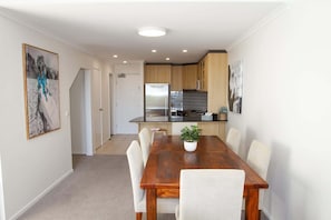 A modern kitchen with a refrigerator, stove, and tiled backsplash.