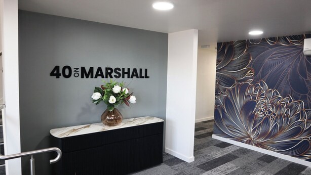 A reception area with a marble counter, a vase of white flowers, and a wall with the text "40&MARSHALL". - 40 on Marshall Street (Goondiwindi)
