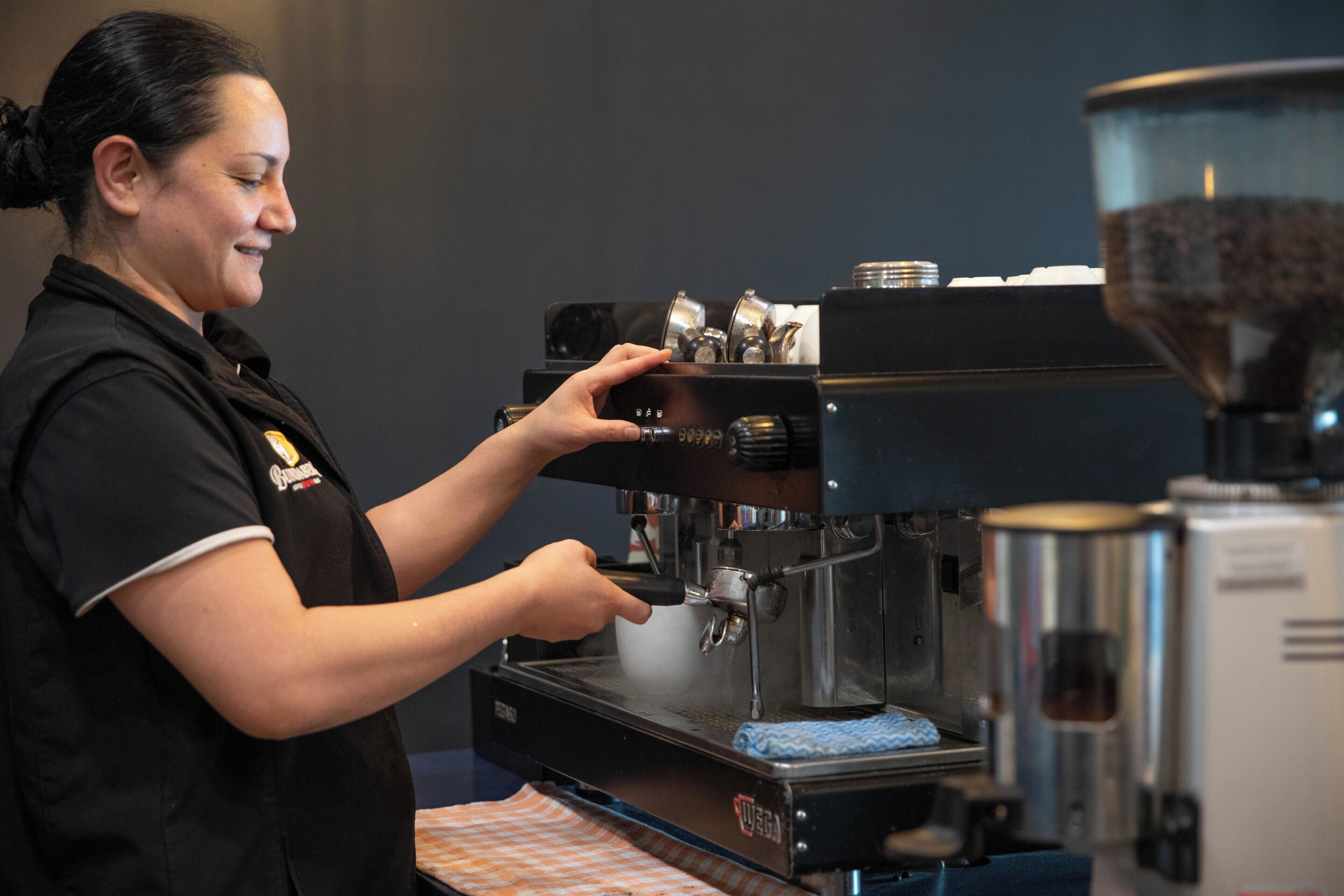 Una persona usando una máquina de café, probablemente en un entorno comercial.