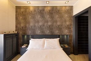A modern bedroom with a large bed, dark headboard, and a textured wall.
