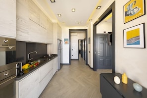 Cozinha moderna com ilha central, eletrodomésticos de aço inoxidável e piso de madeira.
