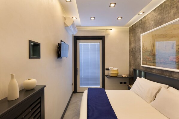Ein modernes Hotelzimmer mit einem Bett, einem Nachttisch und einem großen Gemälde an der Wand.