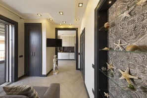 A modern living room with a sofa, a statue, and a decorative wall with shells and starfish. - 3BR Sorrento Apt with SeaView Terrace (Sorrento)