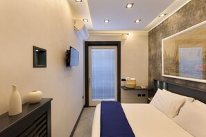 Een moderne hotelkamer met een bed, nachtkastje en een groot schilderij aan de muur.