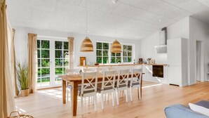 A spacious kitchen with a central island, large windows, and a modern pendant light. - "Gedda" -  from the sea by Interhome (Hals)