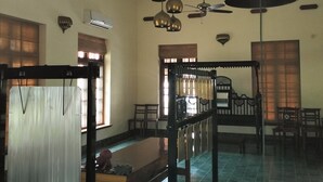 A spacious room with a ceiling fan, hanging lamps, and a large drum. - Svatma Mayavaram (Kuthalam)