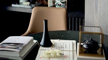 A table with a book, a black vase, a framed picture, and a small decorative item.