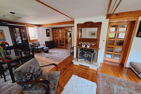Spacious open-concept living & dining room space with decorative fireplace.