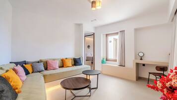 Suite Deluxe, balcón, vista parcial al mar | Área de sala de estar