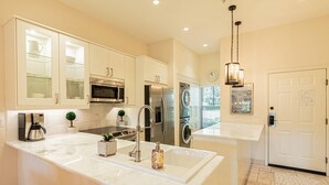 A modern kitchen with stainless steel appliances, a large island, and a hanging light fixture. - Greenlinks/Lely Condo-1st flr,end unit,Bldg.100/3BR,3BA ensuites/Upscale,Newly Renovated w/lk view (Naples)