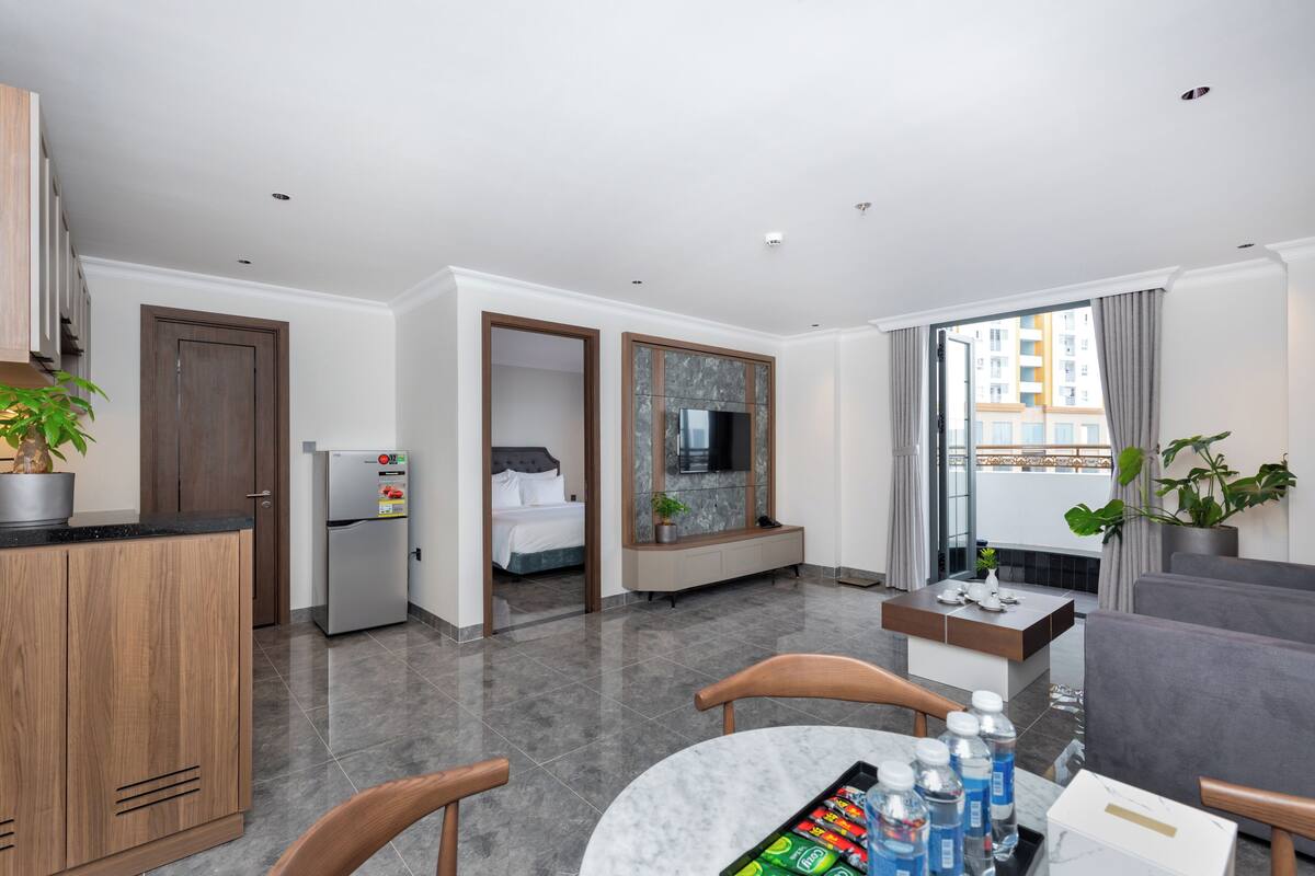 Una habitación de hotel moderna con cocina, comedor y dormitorio.