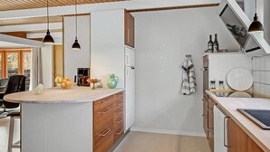 A modern kitchen with a central island, wooden cabinets, and pendant lighting. - "Berner" - 30km from the sea by Interhome (Toftlund)